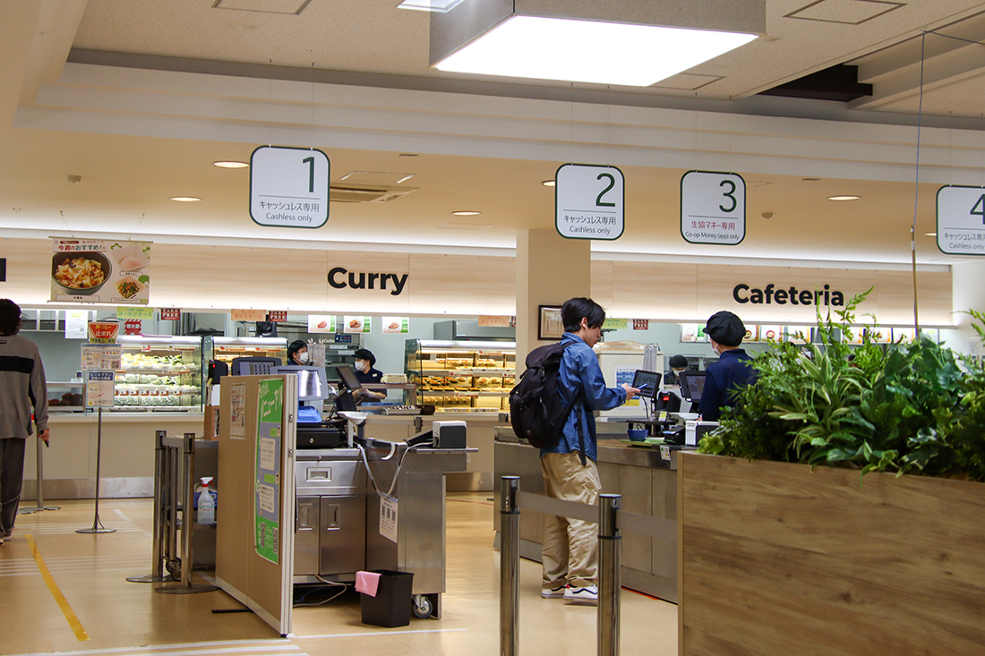 大学の食堂で、学生がキャッシュレスレジで会計をしている様子