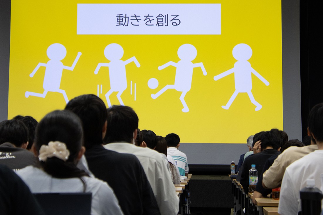 「動きを創る」と表示された画面を見つめる教室内の参加者たち