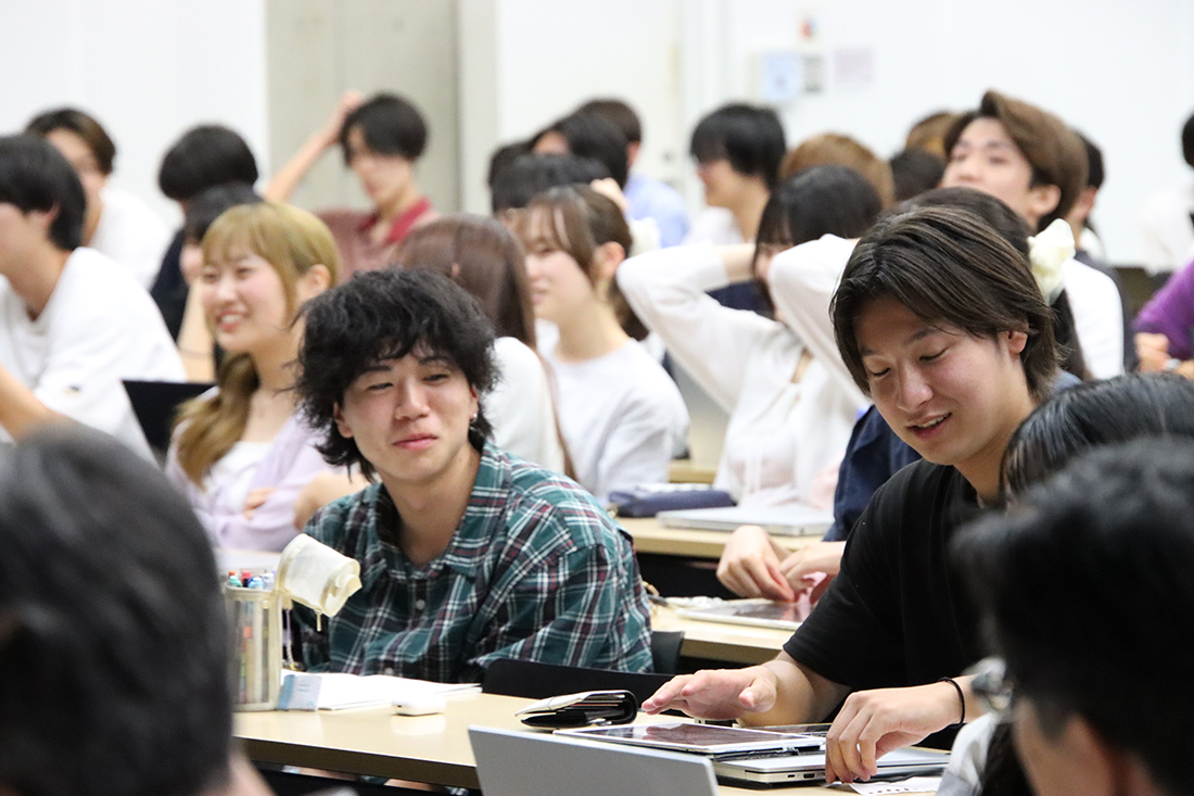 ノートやPCを使って講義を受ける学生たちの様子