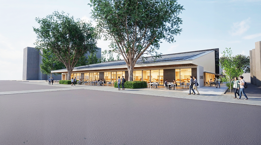 白い建物O-BASEとガラス張りの壁面、前に並ぶテラス席と大きな木がある開放的な風景