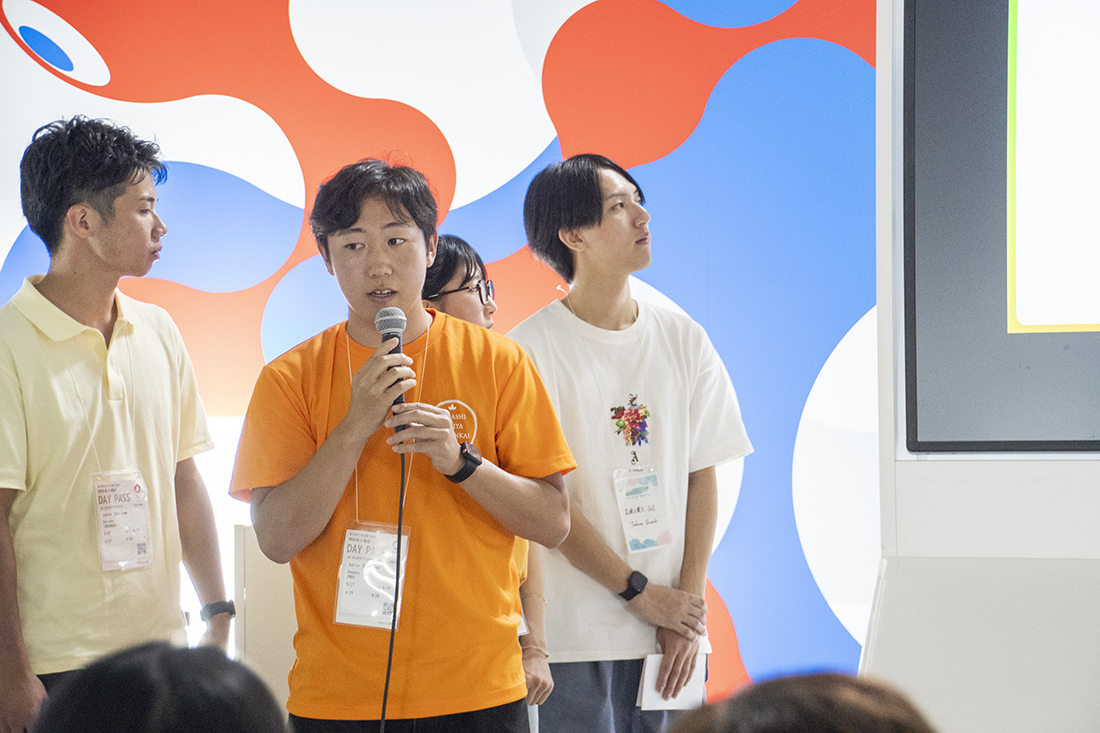 スクリーンを見ながらプレゼンを行う登壇者たち